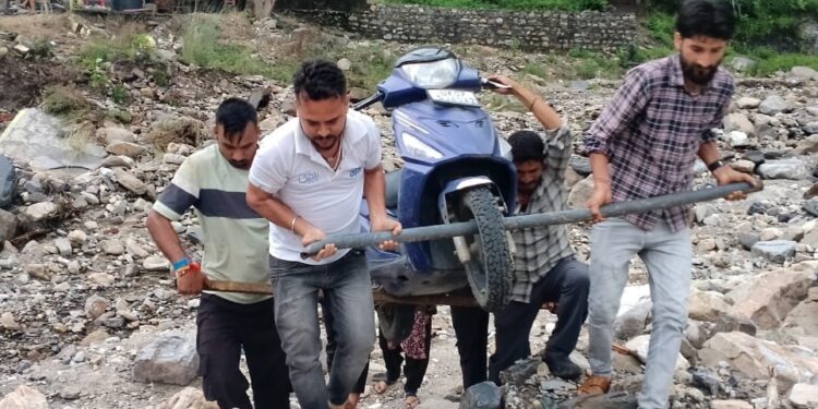 भारी बारिश के बाद टिहरी जिले  के सीतापुर में टूटी सड़क, स्कूटी कंधे पर उठाकर पार कर रहे लोग